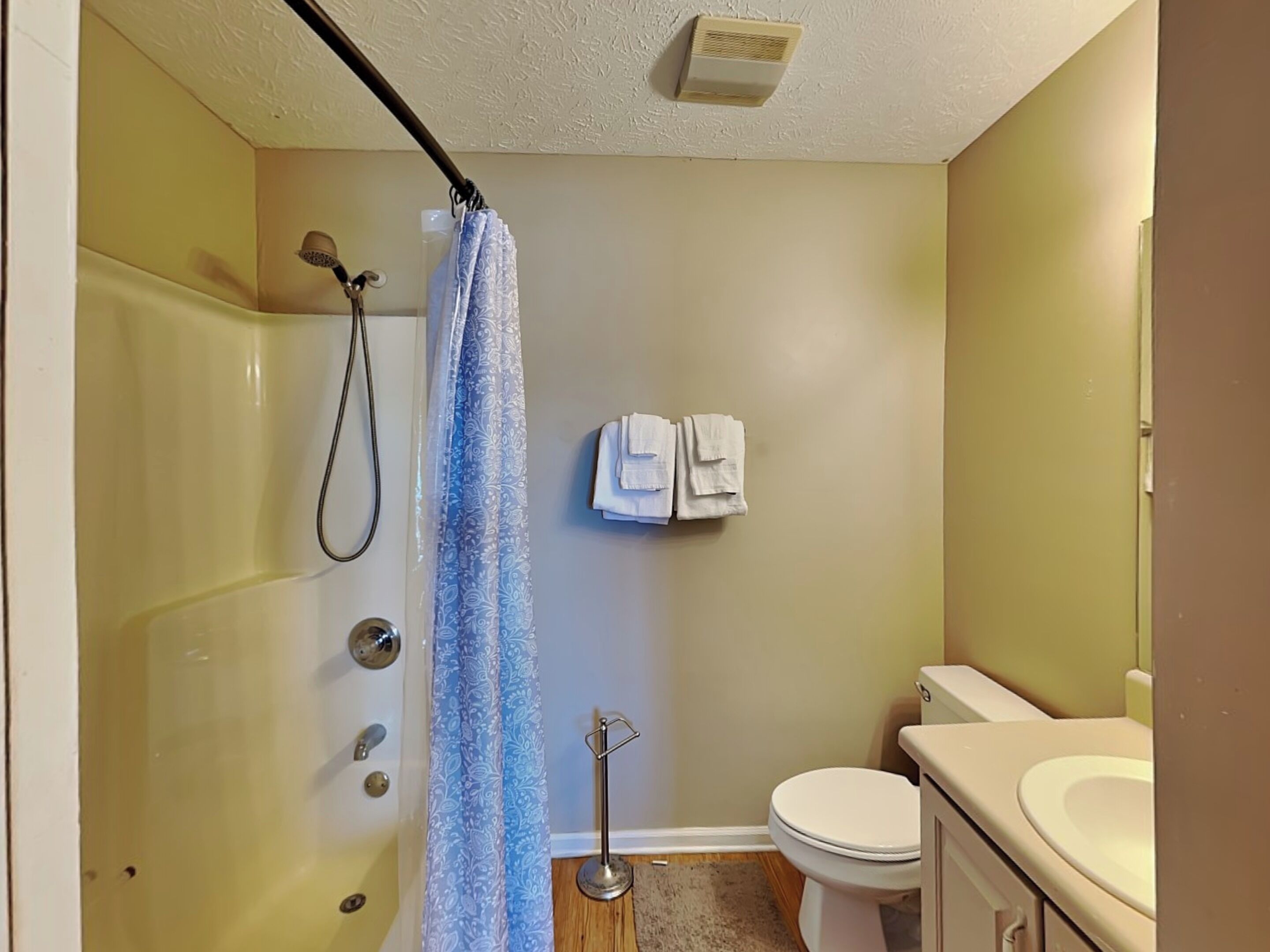 Een badkamer met een bad, toilet en wastafel.