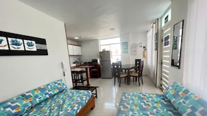 A compact living space with two sofas, a kitchenette, and a dining area.
