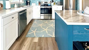 A modern kitchen with white cabinets, stainless steel appliances, and a blue accent wall. - Waterfront Duplex w/Dock | Near Damon Point Beach (Ocean Shores)