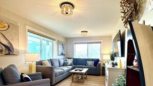A modern living room with a sectional sofa, a coffee table, and a decorative plant.