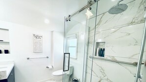 Ein modernes Badezimmer mit Glasdusche, Toilette und Waschbecken.