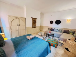 Une chambre à coucher comprenant un lit, un canapé, une petite table et un élément décoratif mural.