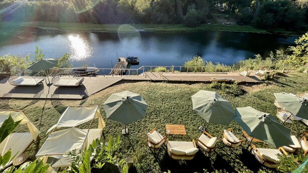 Une terrasse au bord du lac, avec des sièges extérieurs et une jetée qui s’avance dans l’eau.