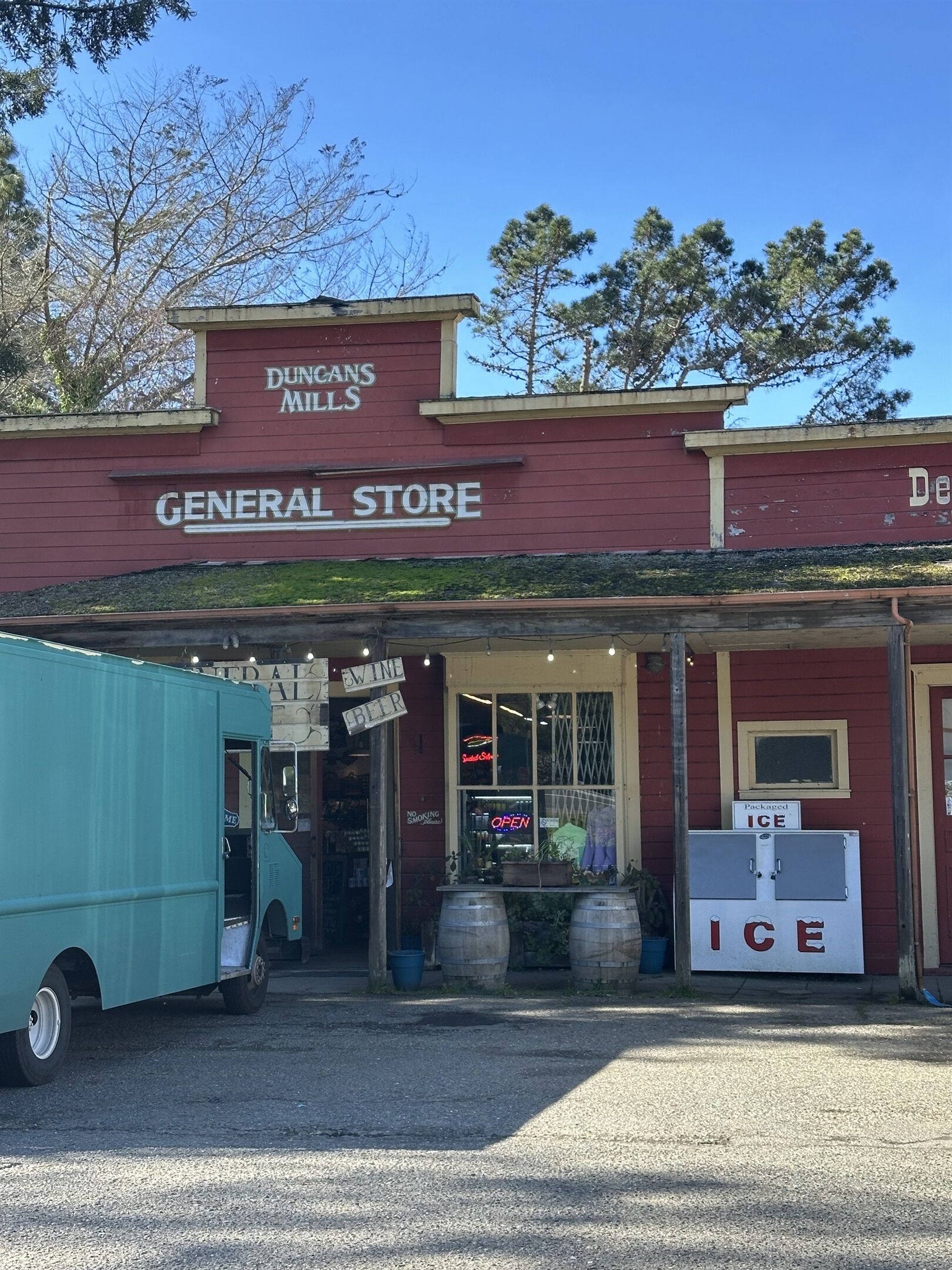 Un edificio con un letrero que dice "DUNCANS MILLS GENERAL STORE" y un camión estacionado afuera.