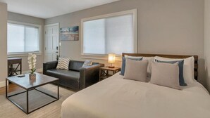 Ein Hotelzimmer mit einem großen Bett, einer Couch, einem Couchtisch und einer Lampe.