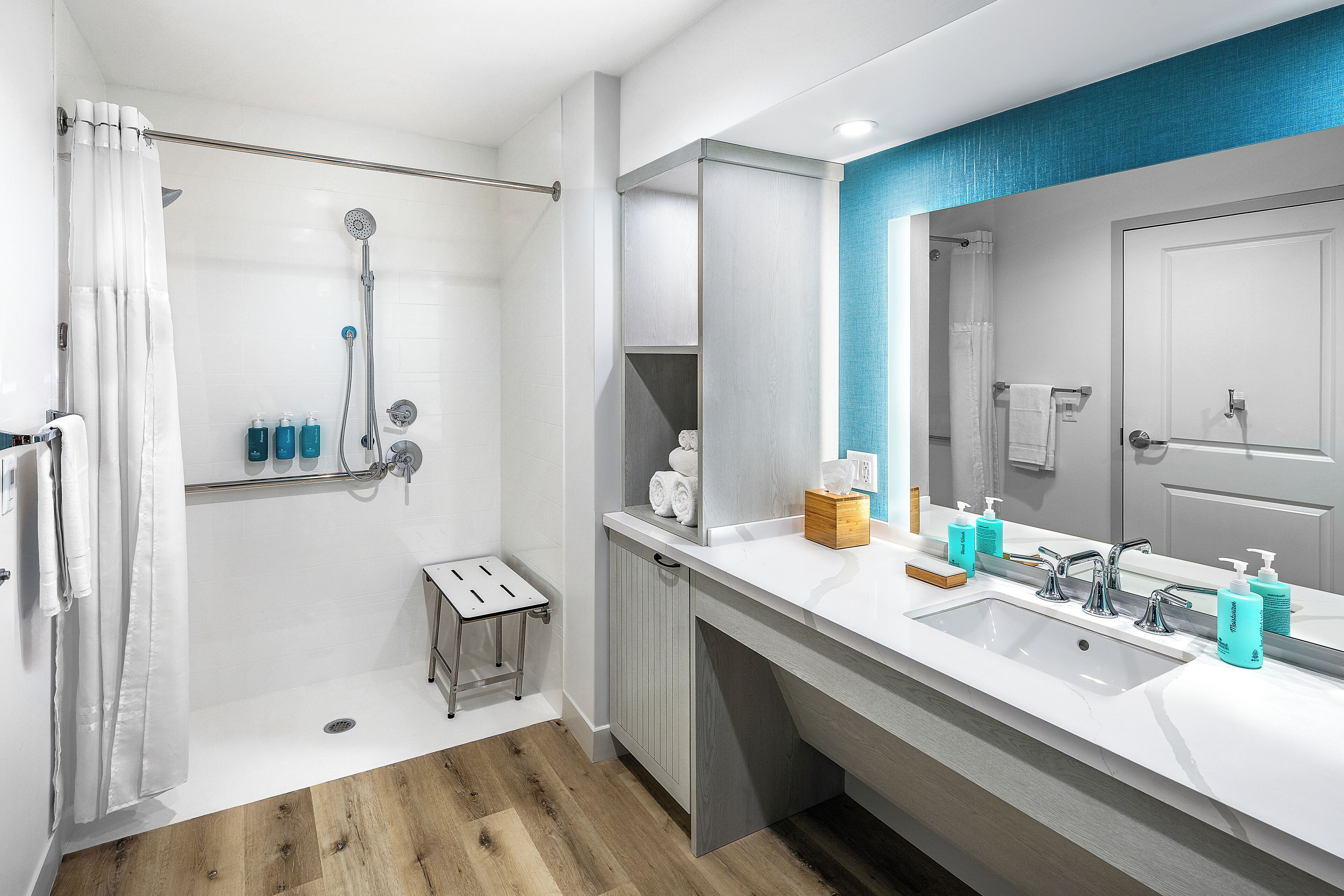 Une salle de bain moderne équipée d’une douche, d’un lavabo et d’un meuble-lavabo.
