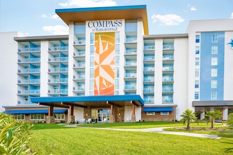 A multi-story hotel with a prominent sign reading "Compass by Margaritaville."