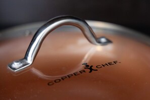 Close-up van een deksel van een waterkoker, merknaam 'Copper Chef' zichtbaar.