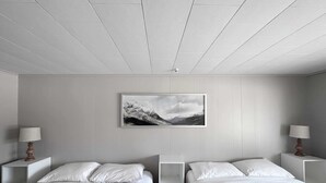 Een hotelkamer met twee bedden, een ingelijst foto aan de muur en bedlampen.