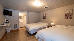 A hotel room with two beds, a TV, a desk with a computer, and a bathroom with a mirror and sink. - Star Gate Room 14 Indian River, MI (Indian River)