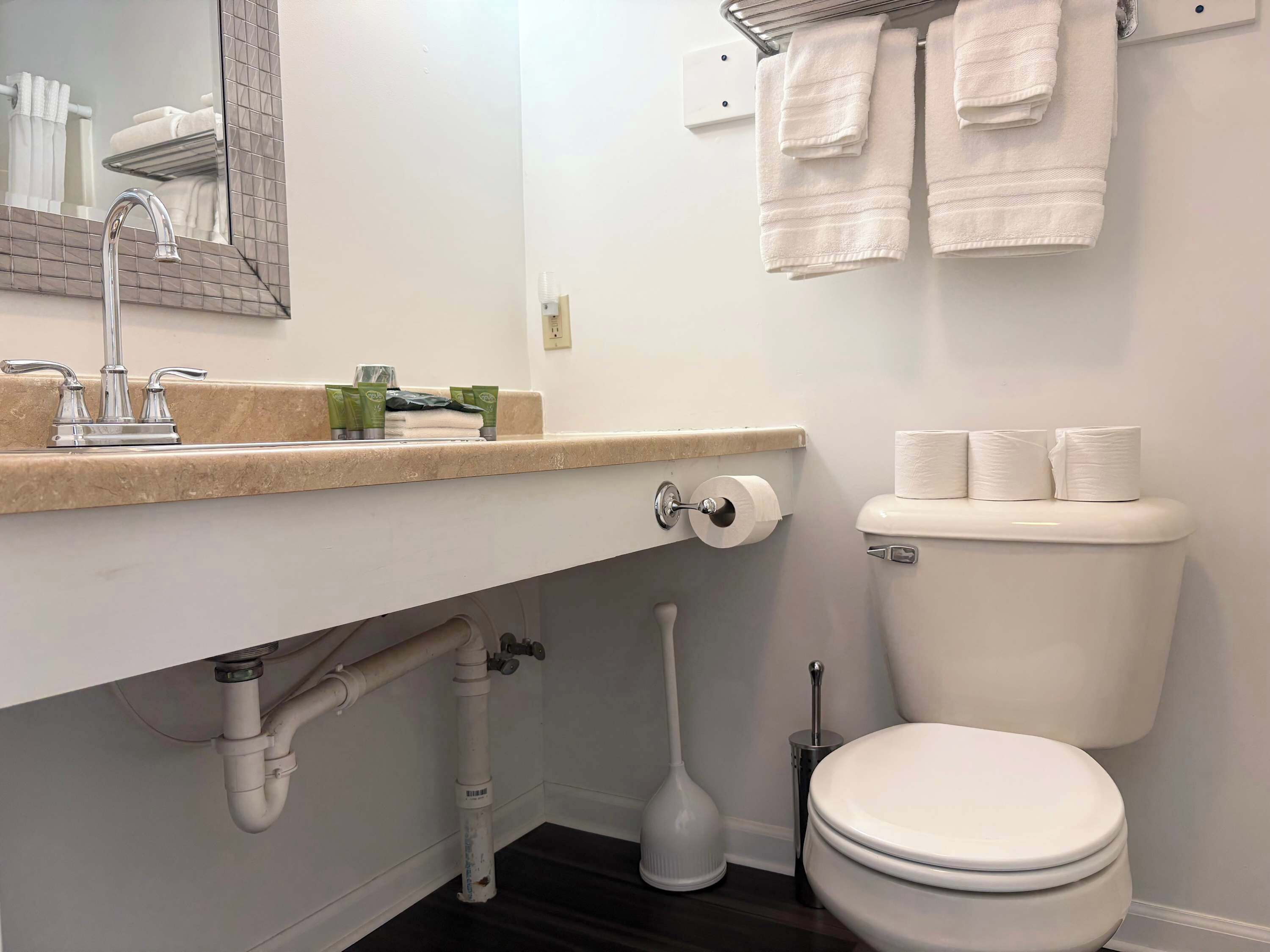 A bathroom with a white sink, a toilet, and a mirror.