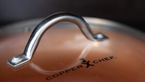 Primer plano de la tapa de una tetera con el nombre de la marca "Copper Chef" a la vista.