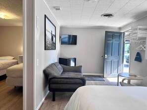 A hotel room with a bed, a sofa, a TV, and a wardrobe. - Star Gate Room 8 Indian River, MI (Indian River)