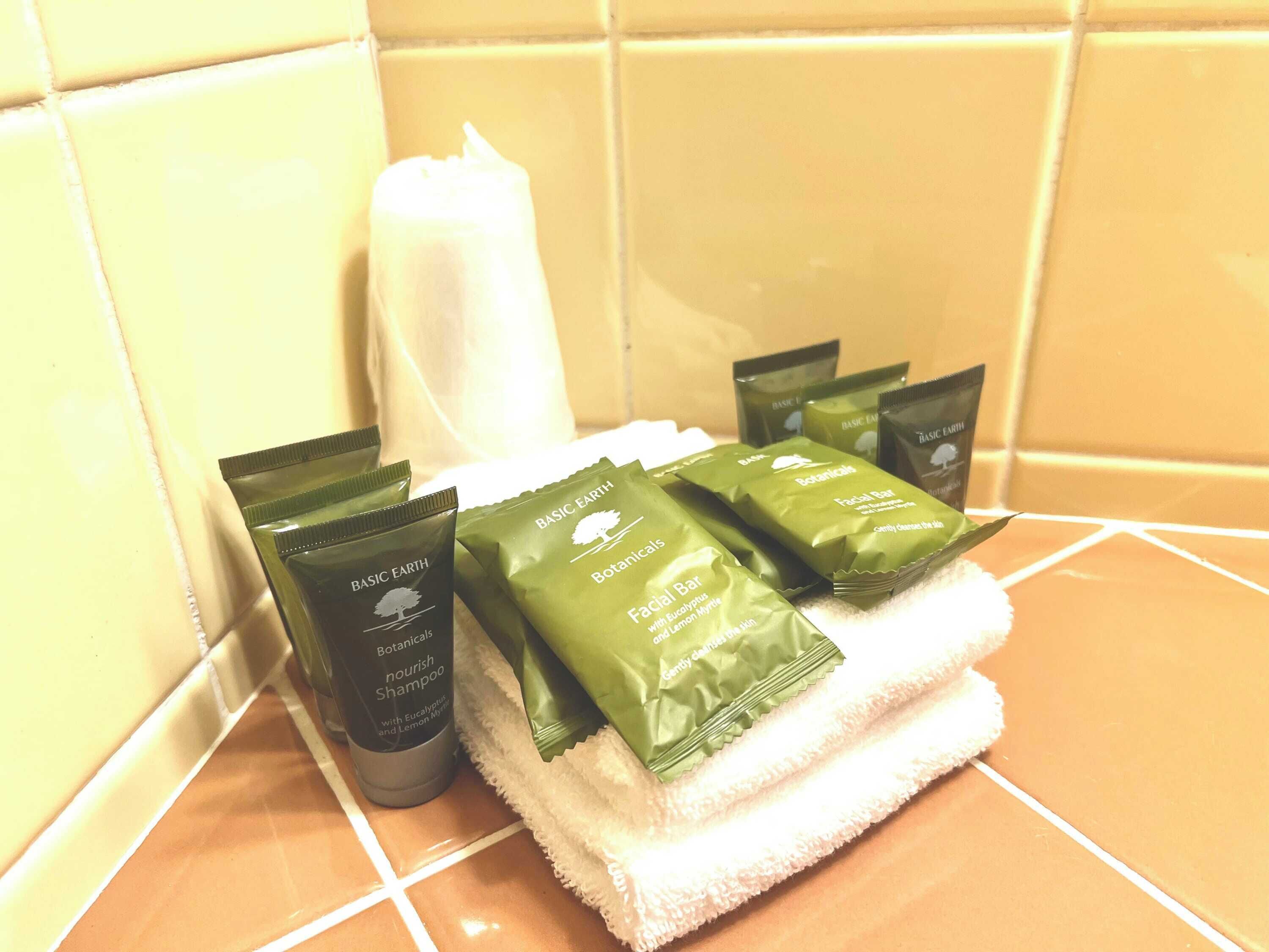 Toiletries including a bottle of shampoo and several facial bar products on a bathroom counter.