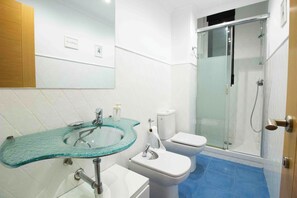 Een douche, een haardroger, een bidet, handdoeken