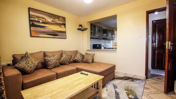 A living room with a brown sofa, a wooden coffee table, and a painting on the wall.