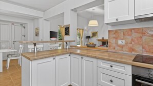 A modern kitchen with white cabinetry, a wooden countertop, and a tiled backsplash. - Villa Samanta - 6 Persons, 2 Bedrooms, Private Pool, Barbecue (Momjan)