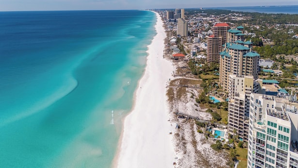 A coastal cityscape with a long sandy beach, high-rise buildings, and a clear blue sky. - Raven's Run by Southern Vacation Rentals (Miramar Beach)