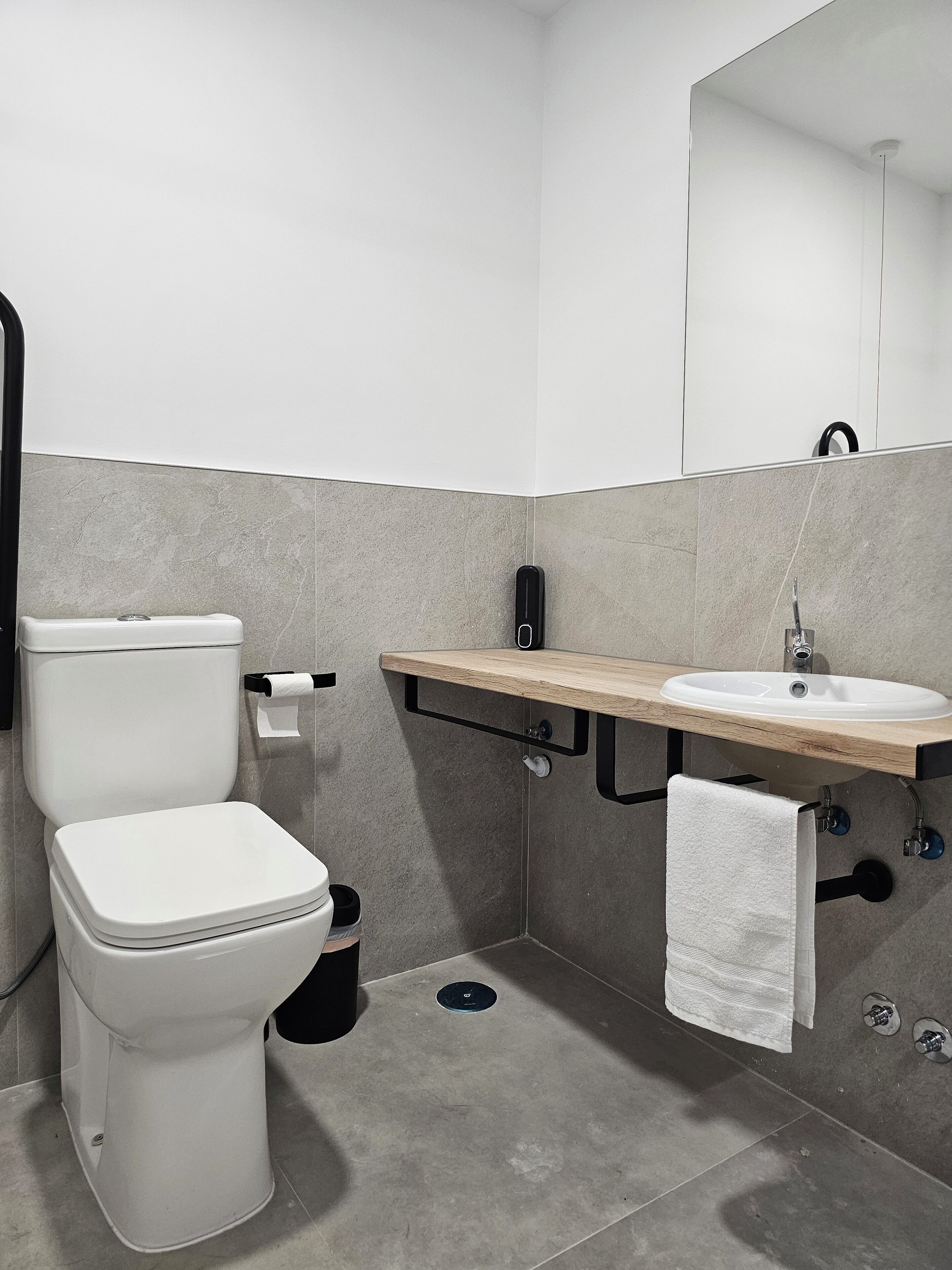 A modern bathroom with a toilet, sink, and mirror.