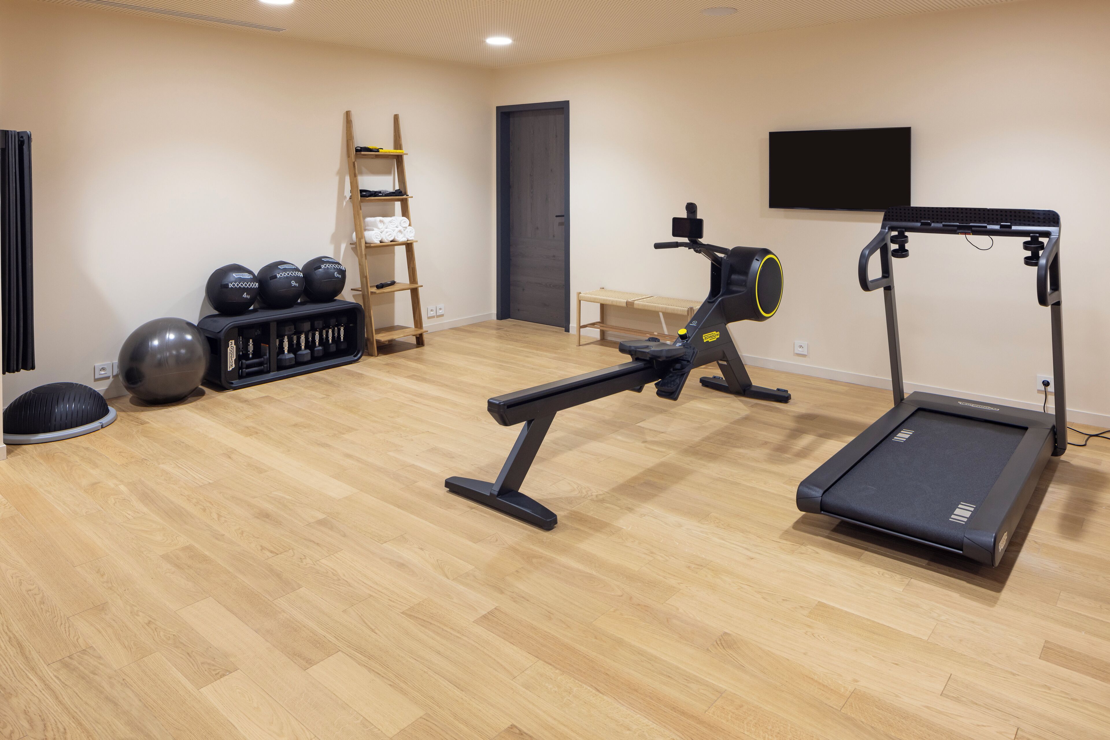 Une salle de sport équipée d’un tapis de course, d’un vélo d’exercice et de divers appareils de musculation.