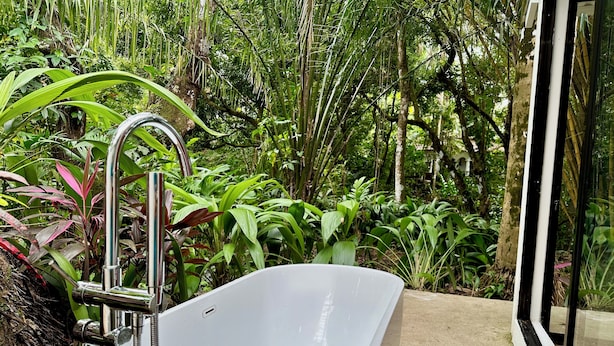 A white freestanding bathtub in a lush, green garden setting. - Villa Lapas: Spacious, Lush 2-Bedroom Home & 2-Bedroom Apart, Central, Wildlife! (Quepos)