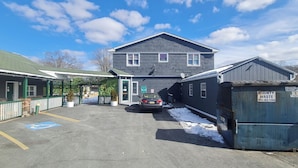 A two-story building with a 'For Rent' sign, a parking lot with a handicapped parking space, and a 'County Waste' dumpster. - Werry'S Cottages And Pub By OYO East Stroudsburg - Weekly Stays (East Stroudsburg)