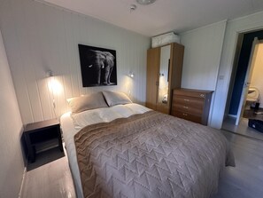 A bedroom with a bed, bedside table, wardrobe, and a wall-mounted elephant artwork. - Studio Apartment in the Center of Alta (Alta)