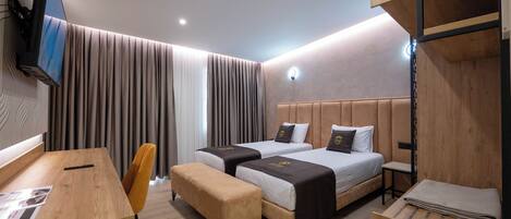 Una habitación de hotel moderna con dos camas, un escritorio, una silla y un televisor montado en la pared.