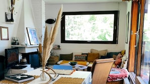 Een gezellige woonkamer met een witte bank, een salontafel en een groot raam.
