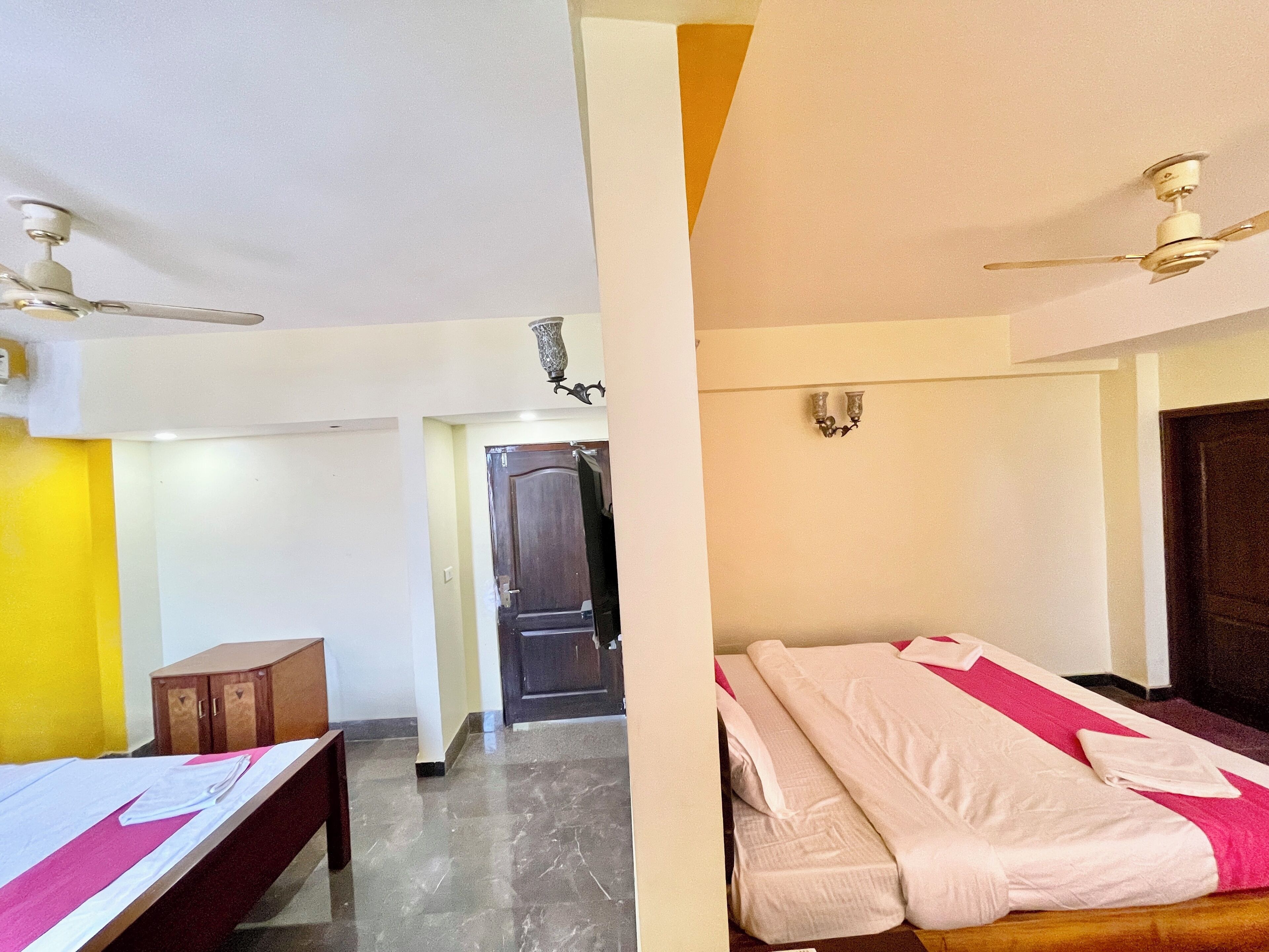 A hotel room with a bed, a desk, and a wardrobe.