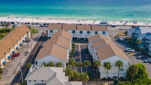 Un hotel costero con varias edificaciones, una playa al fondo y una vista despejada del océano.