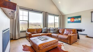 A spacious living room with a large sectional sofa, a wooden coffee table, and a cowhide rug. - Hot Tub & Mtn Views: Townhome in Granby! (Granby)
