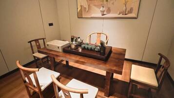 Un coin repas avec une table en bois, des chaises et un tableau accroché au mur.