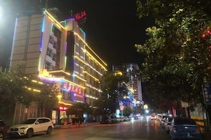 Un hotel bien iluminado con varios pisos y un letrero llamativo.