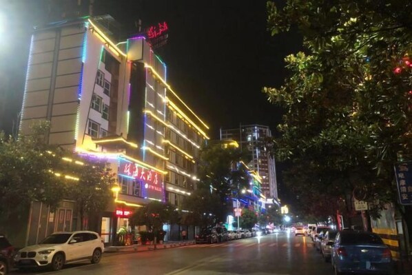 Un hotel bien iluminado con varios pisos y un letrero llamativo.