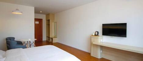 Una habitación de hotel con dos camas, un televisor, una mesita y una silla.