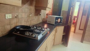 A kitchen with a gas stove, a microwave, and a tiled backsplash.