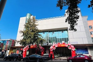 A building with a modern facade, large glass windows, and a prominent entrance with red and white decorations.
