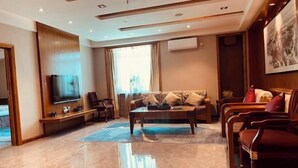 A modern living room with a flat-screen TV, a sofa set, and a coffee table. - Dongtai Dashijie Hotel (Kuandian)