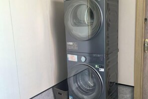 Una lavadora y secadora apiladas en una esquina de la habitación.