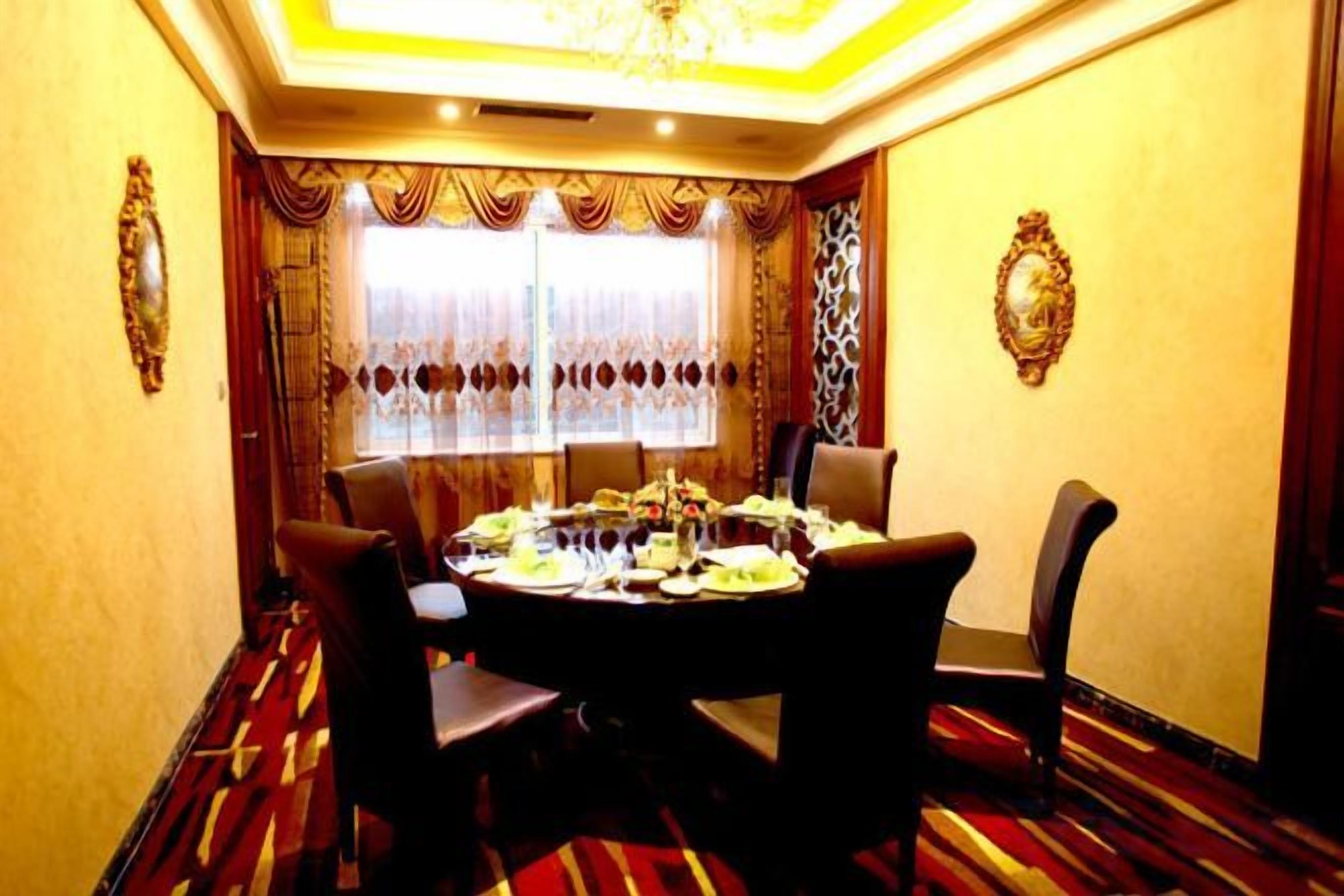A dining room with a round table set for a meal, surrounded by chairs.