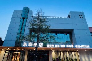 Un edificio moderno con una amplia fachada de vidrio y una entrada destacada.