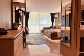 A hotel room with a bed, a desk, a chair, a mirror, and a large window with curtains. - Dongtai Dashijie Hotel (Kuandian)