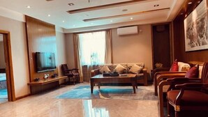 A modern living room with a flat-screen TV, a sofa set, and a coffee table. - Dongtai Dashijie Hotel (Kuandian)
