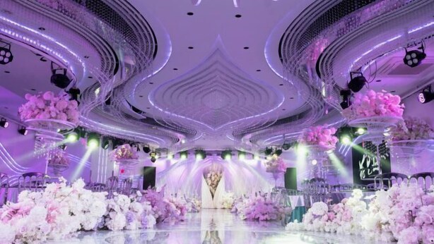 A luxurious venue with a central stage, surrounded by floral arrangements and a reflective floor. - Dongtai Dashijie Hotel (Kuandian)