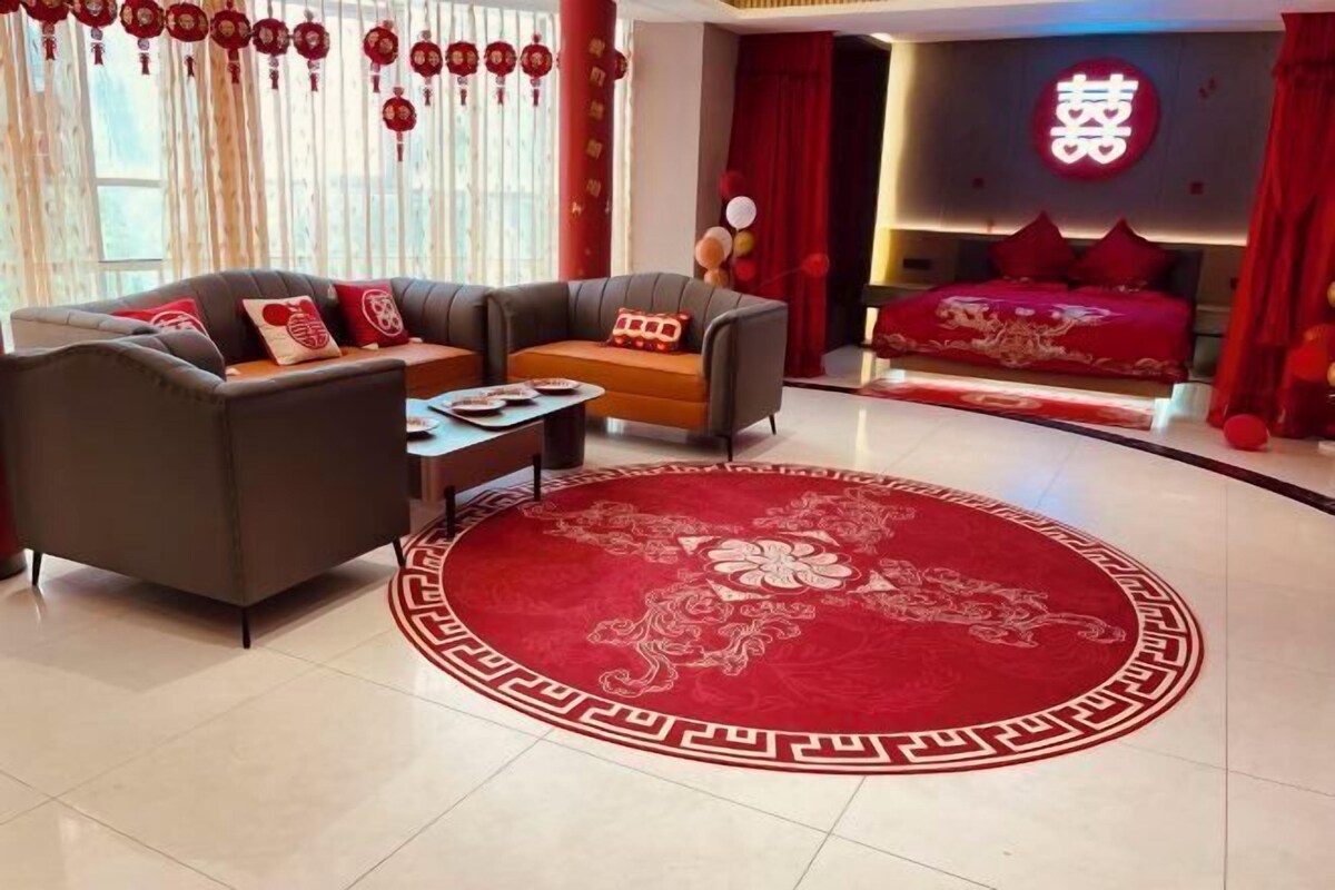 Uma sala de estar moderna com um sofá, uma mesa de centro e um tapete vermelho com um desenho de dragão.