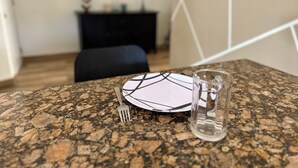 Una mesa con un plato, un tenedor y un vaso de agua.