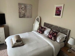 A neatly made bed with white linens and decorative pillows, a bedside lamp, and artwork on the walls. - 2 Bed Flat - Sleeps 4 Antrim Town Centre (Antrim)