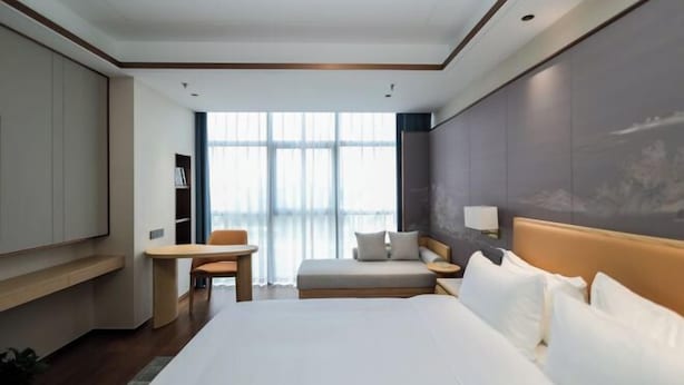 Een moderne hotelkamer met een groot bed, een bureau en een zithoek.