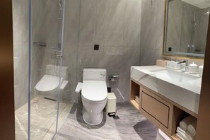 A modern bathroom with a glass-enclosed shower, a toilet, and a vanity with a mirror. - Suzhou Water Sky Hotel (Suzhou)